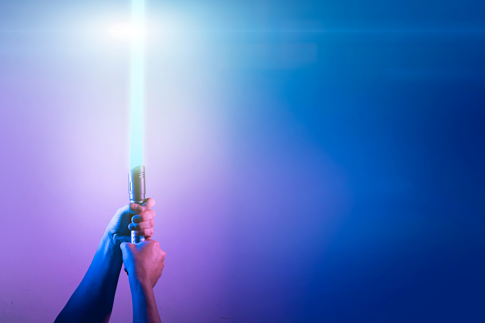 a fantastic laser sword lightsaber in the hands of a man